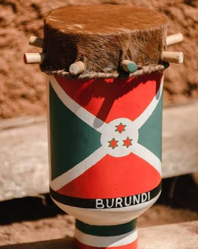A Burundian Ingoma drum: a hide head laced to the body with wooden pegs, the body painted with the national flag of Burundi