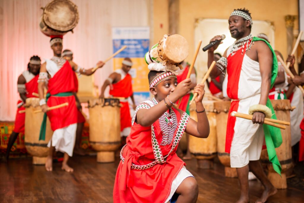 A young drummer performs at the front while the ensemble drums behind him